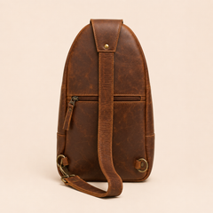 Back of the Crazy Horse Brown Metro sling, showing the zipped back pocket, leather strap and antique brass swivel hook — view 3