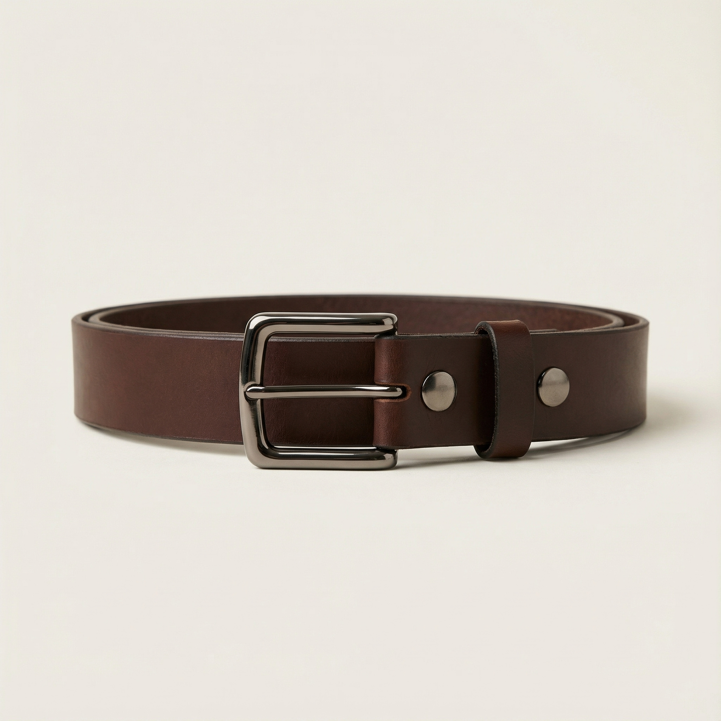 Bellvari Nightfall black leather belt rolled, showing matte finish.