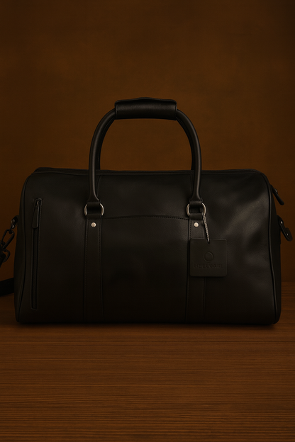 Black leather duffel bag on a dark brown background