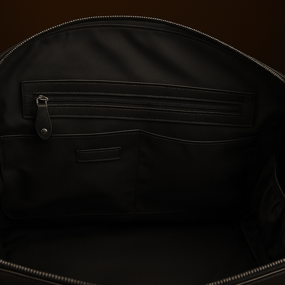 Close-up of a black backpack with zippers and stitching details on a dark background