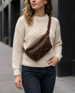 A woman wearing the Bellvari Nomad Sling crossbody in brown crazy-horse full-grain leather. — view 6