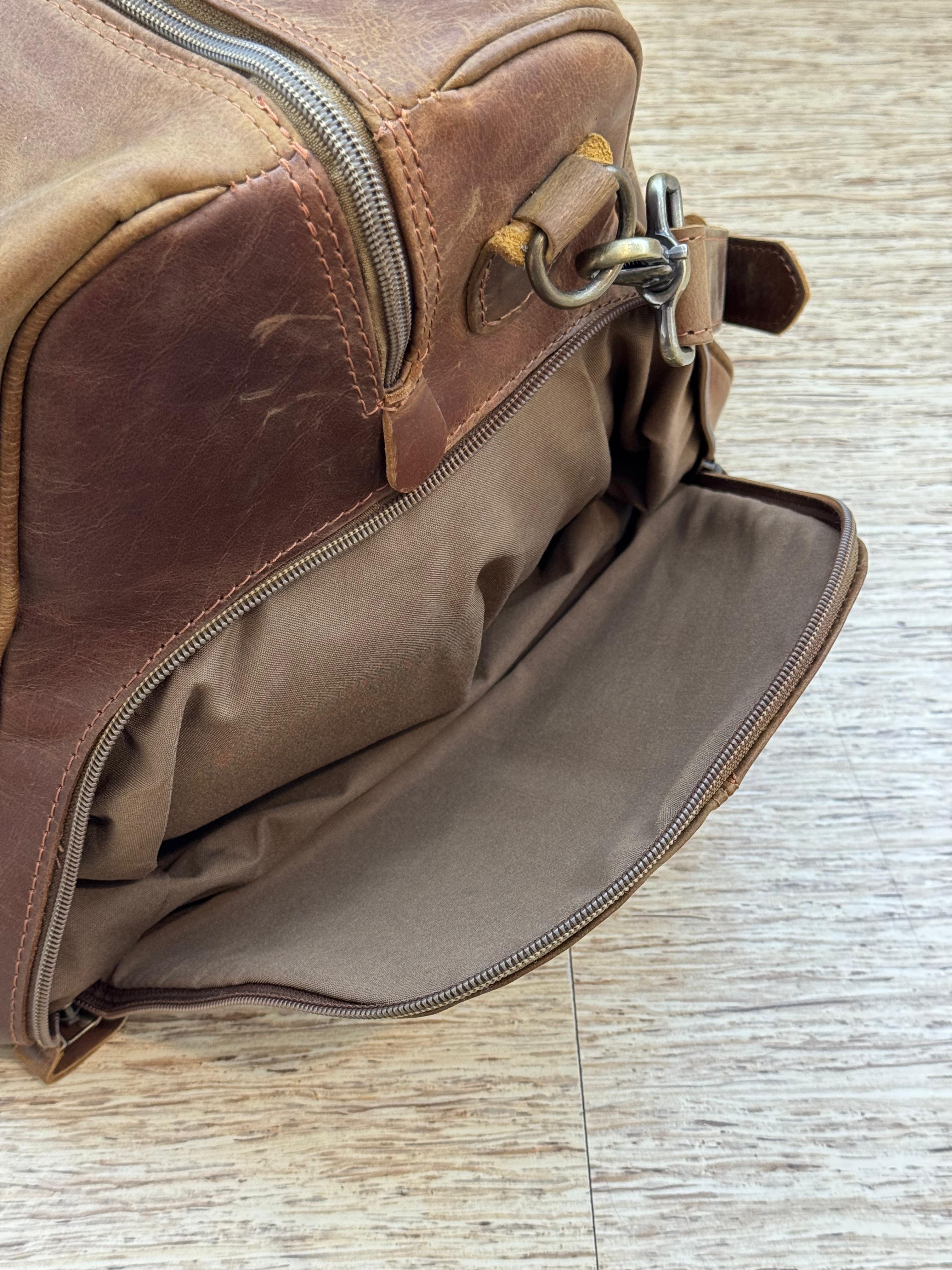Close-up of the open shoe compartment on the Crazy Horse Brown Weekender, with the lining and zipper visible.