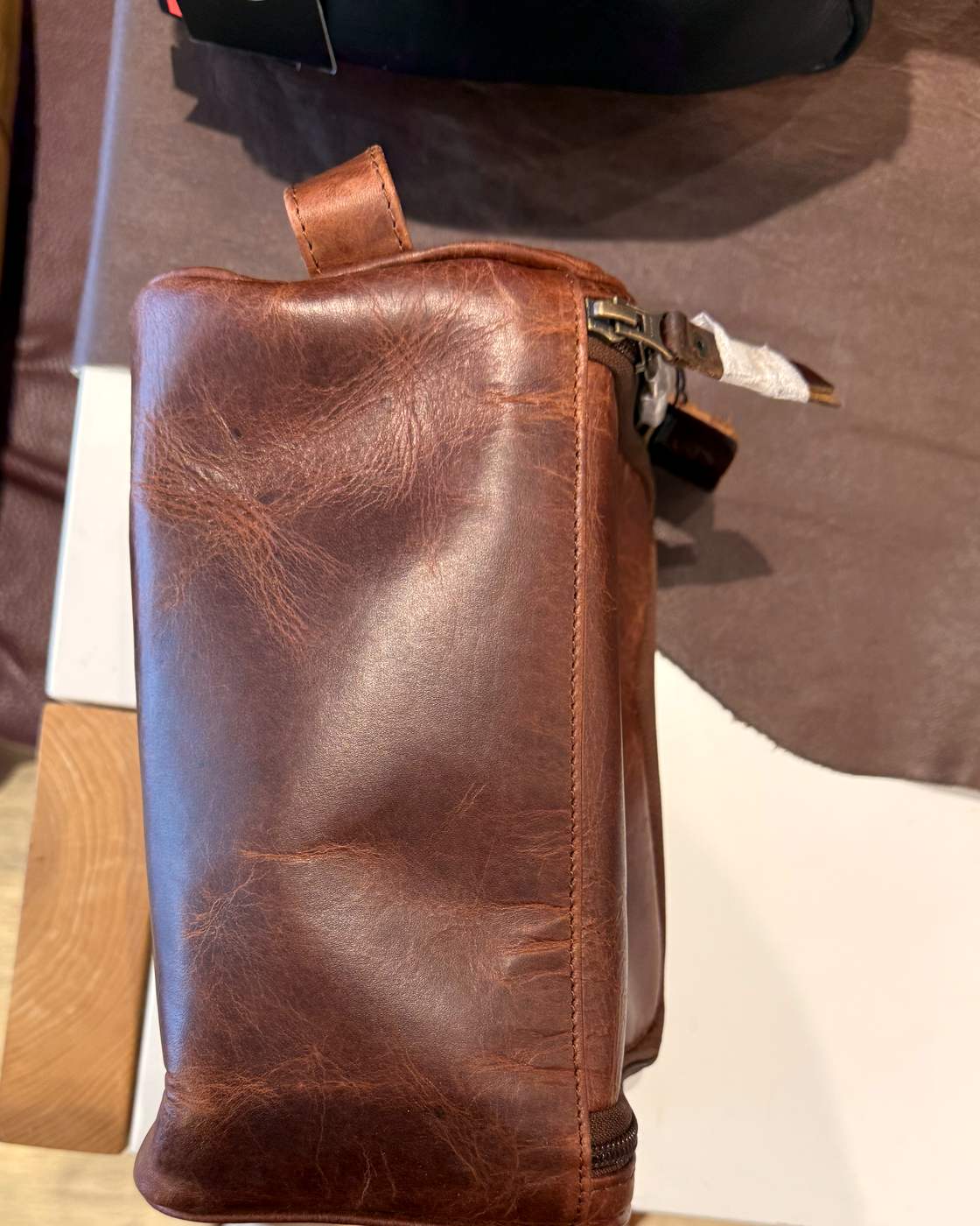 Real photo of the other long side of the dopp kit, with the leather carry loop at the top and the zip pull hanging off the end.
