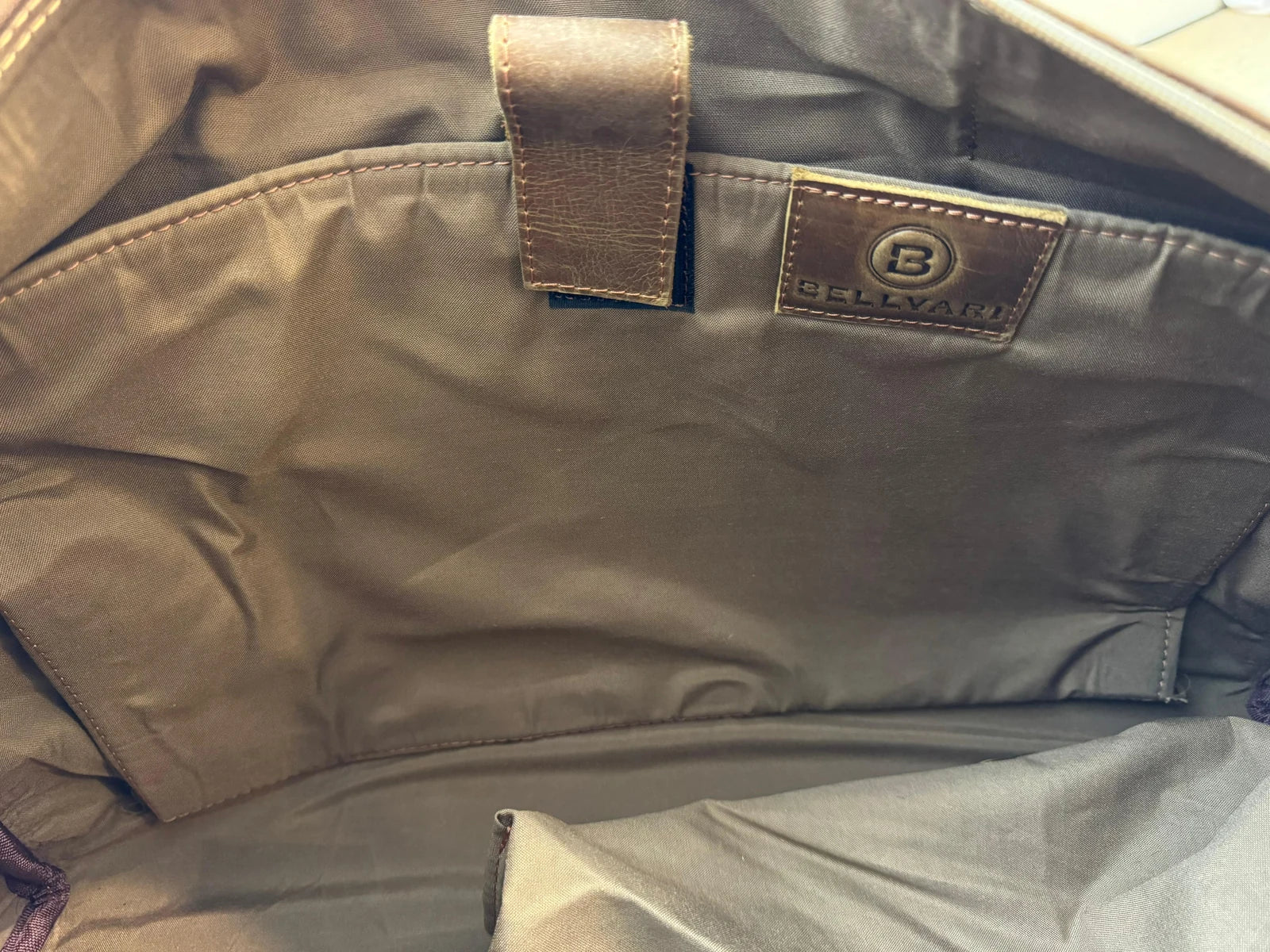 Real photo inside the Crazy Horse Brown Weekender, showing the fabric sleeve, retaining tab, Bellvari patch and lining.